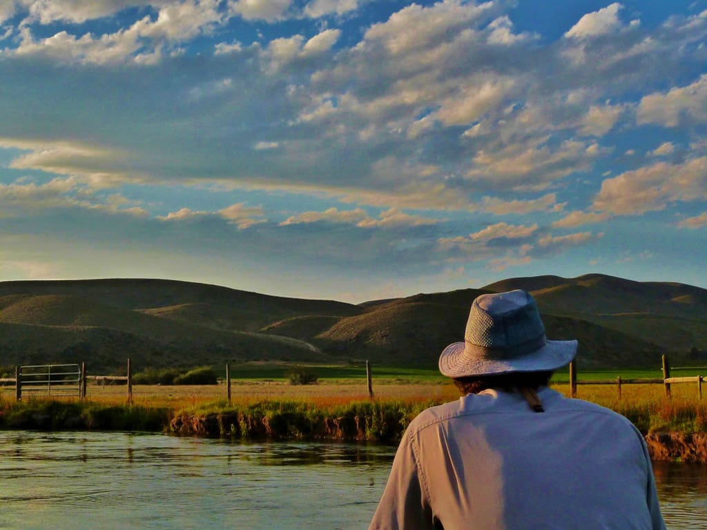 A man standing on the shore of a lake.